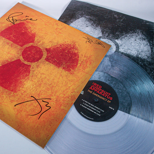 A clear vinyl record by The Red Jumpsuit Apparatus, partially in a sleeve with a yellow and red radiation symbol design. Both the sleeve and record are autographed. The label reads Red Jumpsuit Apparatus – Emergency EP.