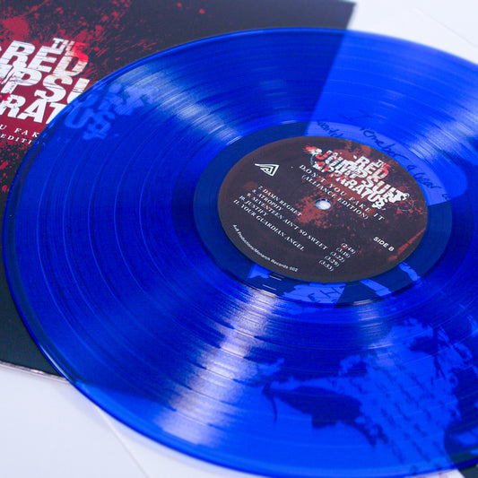 A Clear Blue Variant vinyl record from The Red Jumpsuit Apparatus partially slides out of its album sleeve. The center label lists tracks, while the sleeve features red and white text set against a dark background.